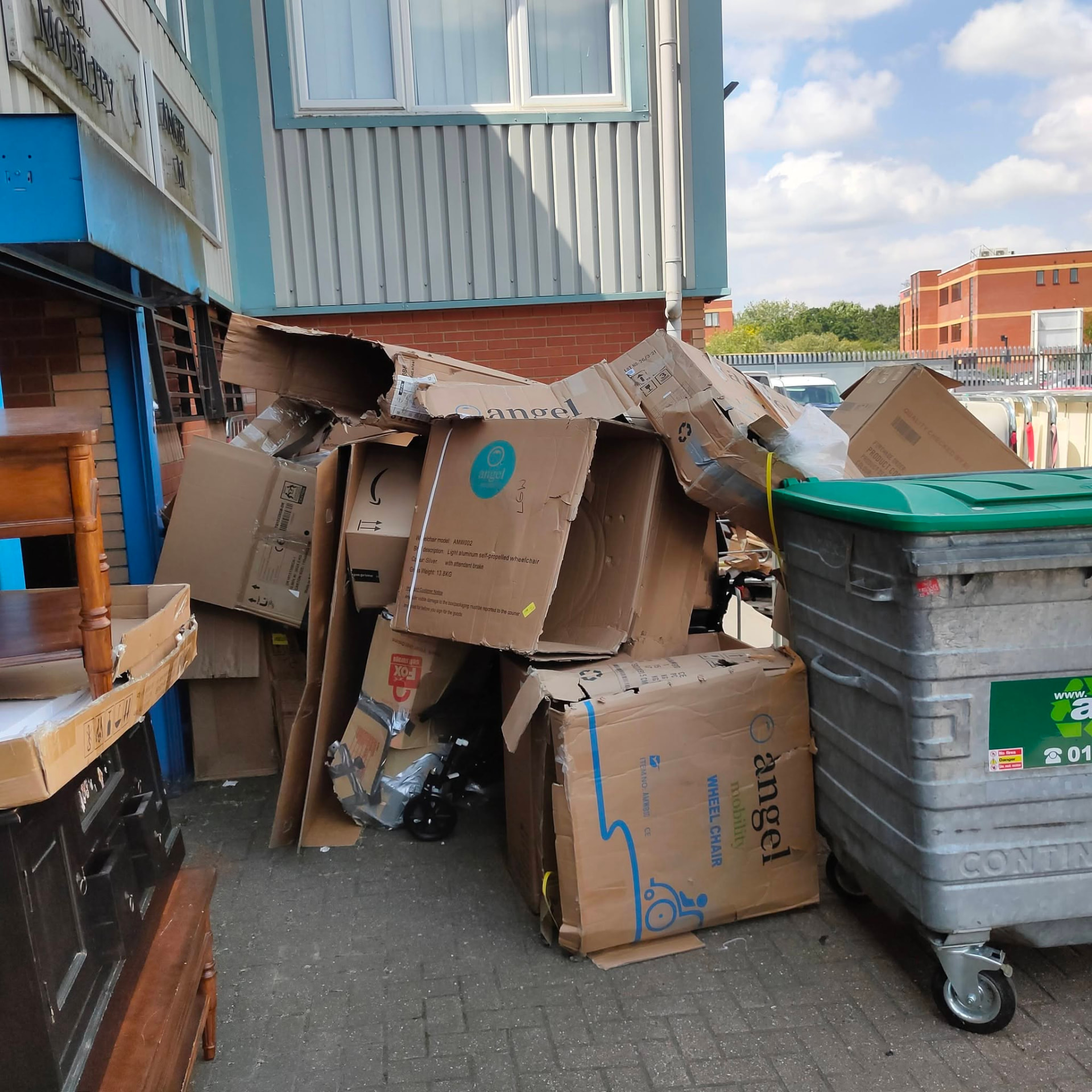 Commercial yard piled with cardboard boxes and furniture before clearance